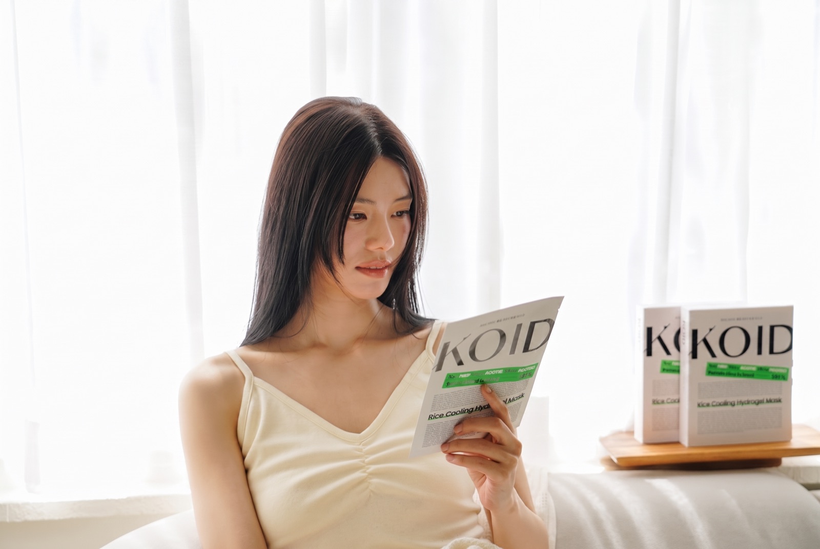 소파에서 코이드 책자를 가까이 들고 읽는 모습