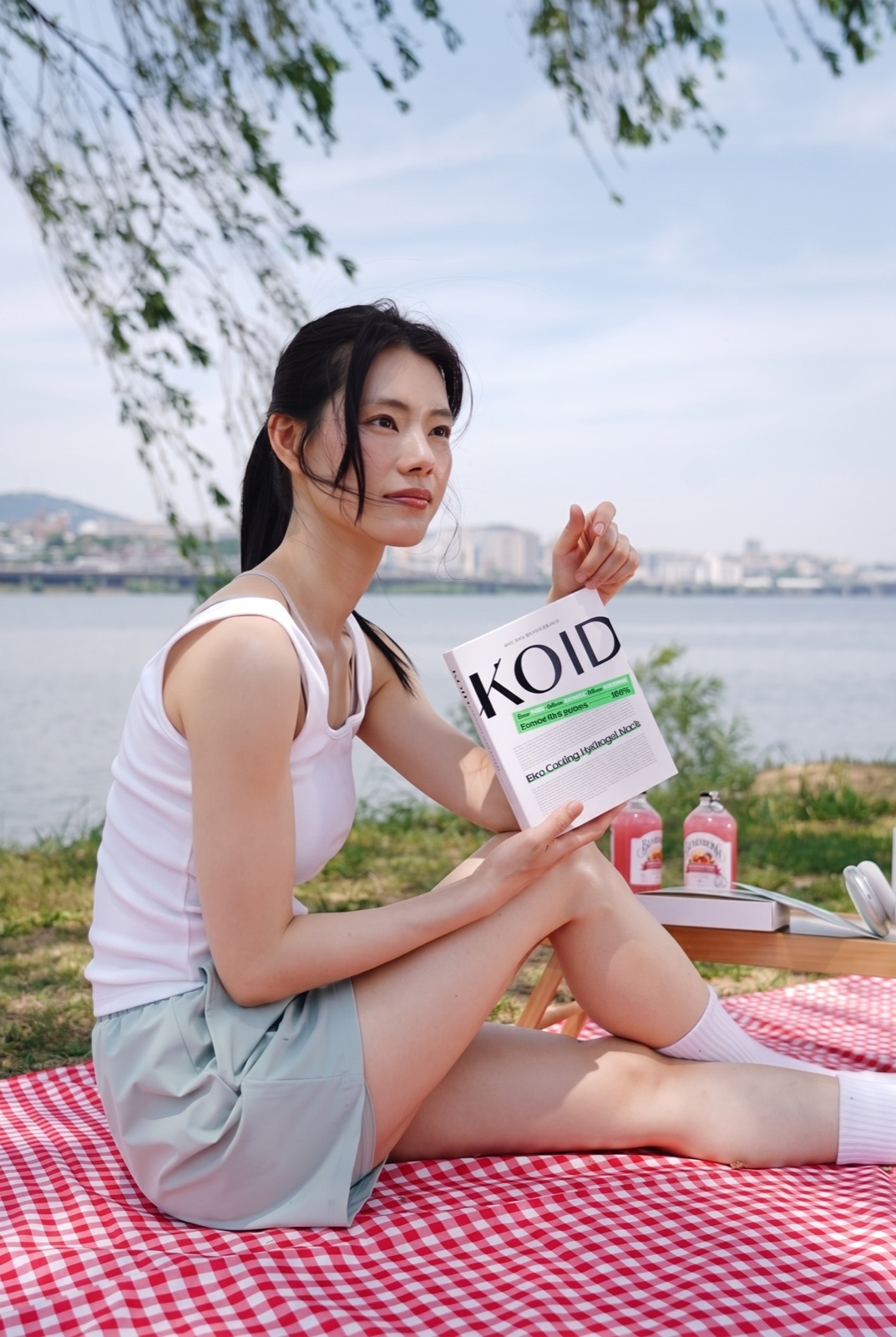 강변 햇살 아래 코이드 패키지를 든 모습